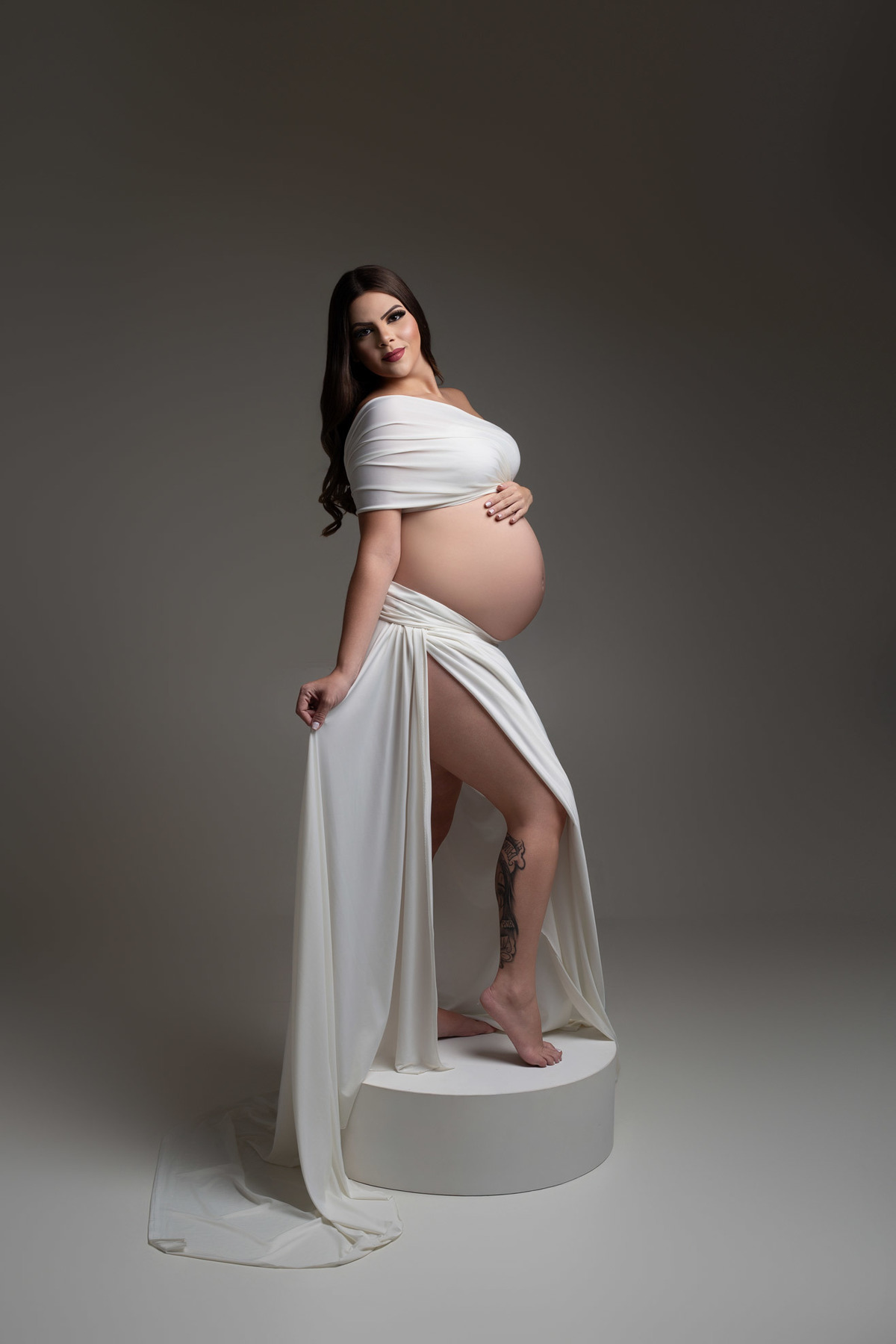 Ensaio de gestante em estúdio em Maringá – PR, com fotografia clean, elegante e atemporal. Realizado por fotógrafa especializada em gestante, em estúdio fotográfico para gestante, com direção profissional e experiência personalizada. gestante elegante 