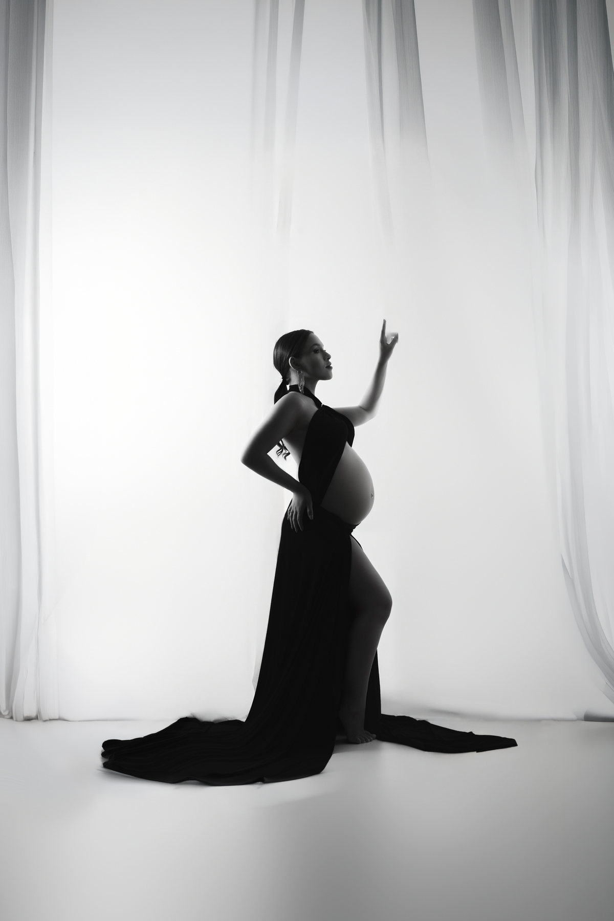 Ensaio de gravidez em Maringá realizado em estúdio, com iluminação suave e estética elegante.