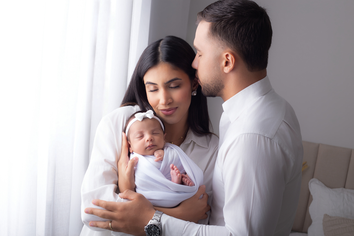Família reunida com o bebê nos primeiros dias de vida em ensaio newborn lifestyle.
