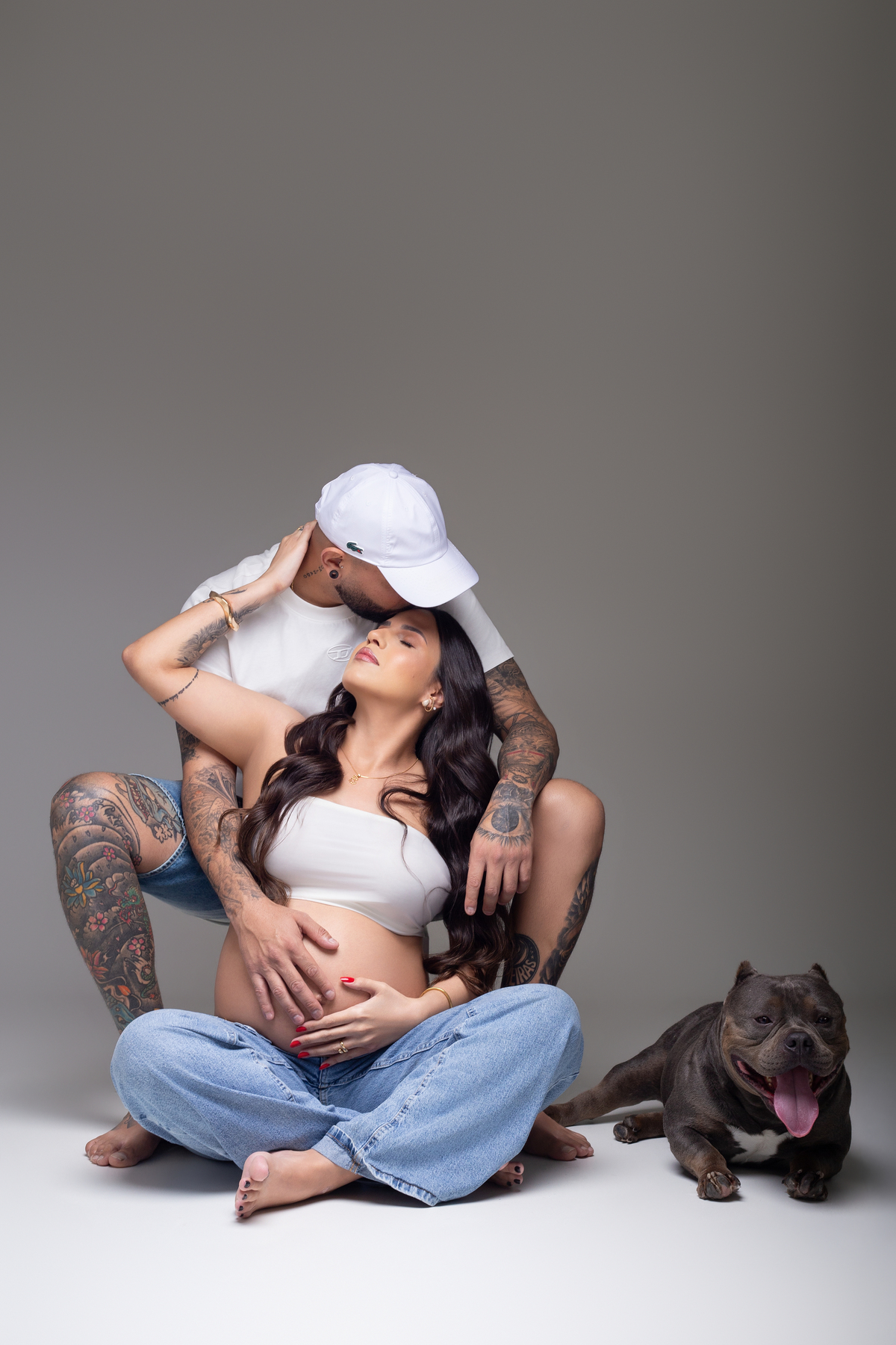 casal em pose para ensaio de gestante fazendo carinho e mostrando conexão 