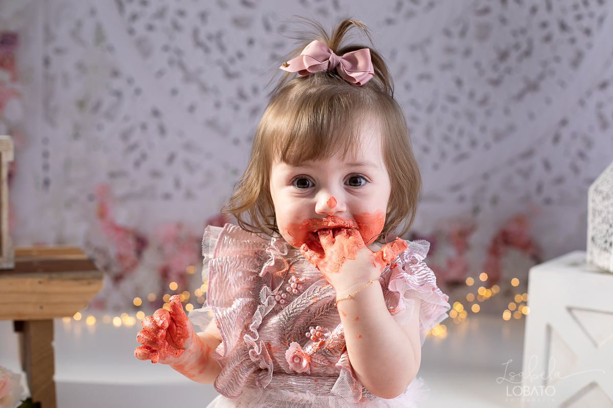 ensaio-fotografico-da-hora-do-bolo-esmagando-o-bolo-smash-the-cake-one-bebe-de-um-ano-acompanhamento-fotografico-de-bebes-fotografa-especializada-em-criancas-em-barbacena-isabela-lobato-fotografia-fundo-fotografico-de-smash-the-cake-cenario-fotografico
