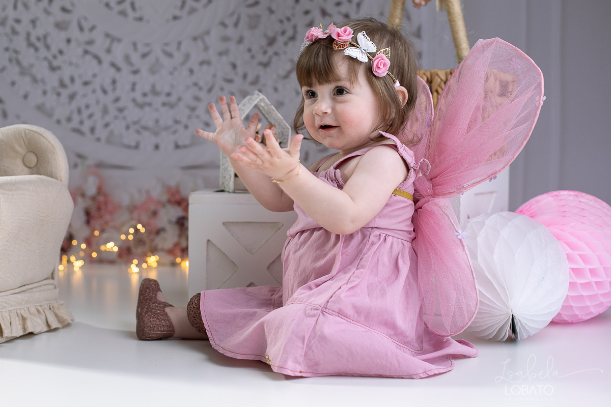 ensaio-fotografico-da-hora-do-bolo-esmagando-o-bolo-smash-the-cake-one-bebe-de-um-ano-acompanhamento-fotografico-de-bebes-fotografa-especializada-em-criancas-em-barbacena-isabela-lobato-fotografia-fundo-fotografico-de-smash-the-cake-cenario-fotografico