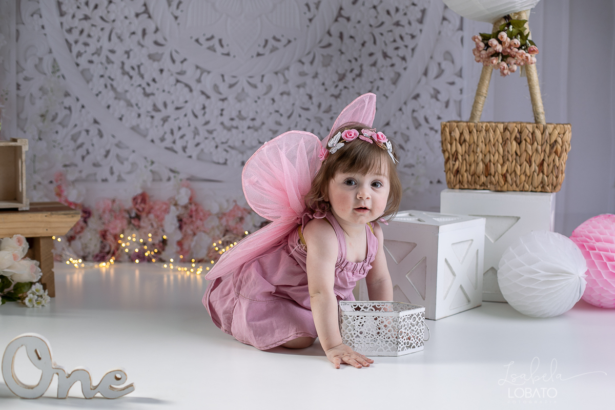 ensaio-fotografico-da-hora-do-bolo-esmagando-o-bolo-smash-the-cake-one-bebe-de-um-ano-acompanhamento-fotografico-de-bebes-fotografa-especializada-em-criancas-em-barbacena-isabela-lobato-fotografia-fundo-fotografico-de-smash-the-cake-cenario-fotografico