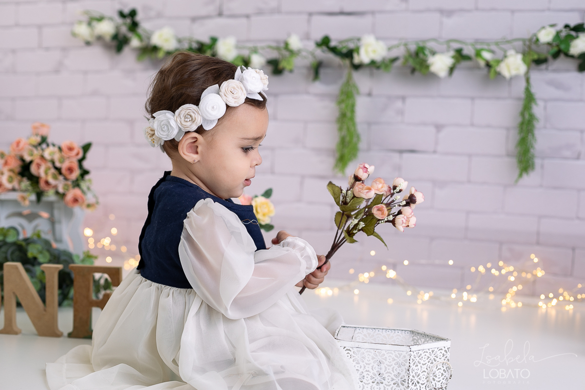 ensaio-fotografico-da-hora-do-bolo-esmagando-o-bolo-smash-the-cake-one-bebe-de-um-ano-acompanhamento-fotografico-de-bebes-fotografa-especializada-em-criancas-em-barbacena-isabela-lobato-fotografia-fundo-fotografico-de-smash-the-cake-cenario-fotografico