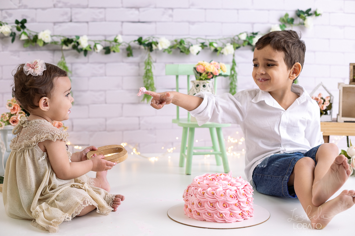 ensaio-fotografico-da-hora-do-bolo-esmagando-o-bolo-smash-the-cake-one-bebe-de-um-ano-acompanhamento-fotografico-de-bebes-fotografa-especializada-em-criancas-em-barbacena-isabela-lobato-fotografia-fundo-fotografico-de-smash-the-cake-cenario-fotografico