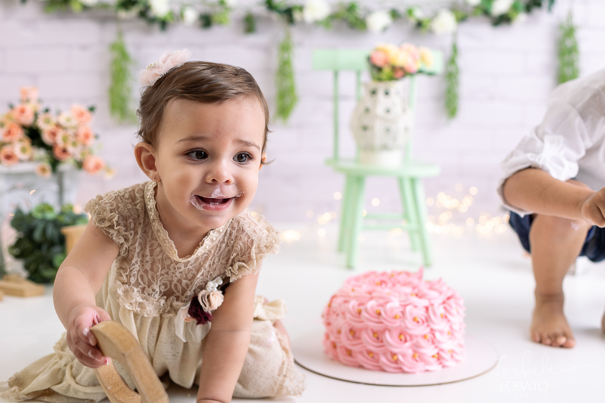 ensaio-fotografico-da-hora-do-bolo-esmagando-o-bolo-smash-the-cake-one-bebe-de-um-ano-acompanhamento-fotografico-de-bebes-fotografa-especializada-em-criancas-em-barbacena-isabela-lobato-fotografia-fundo-fotografico-de-smash-the-cake-cenario-fotografico