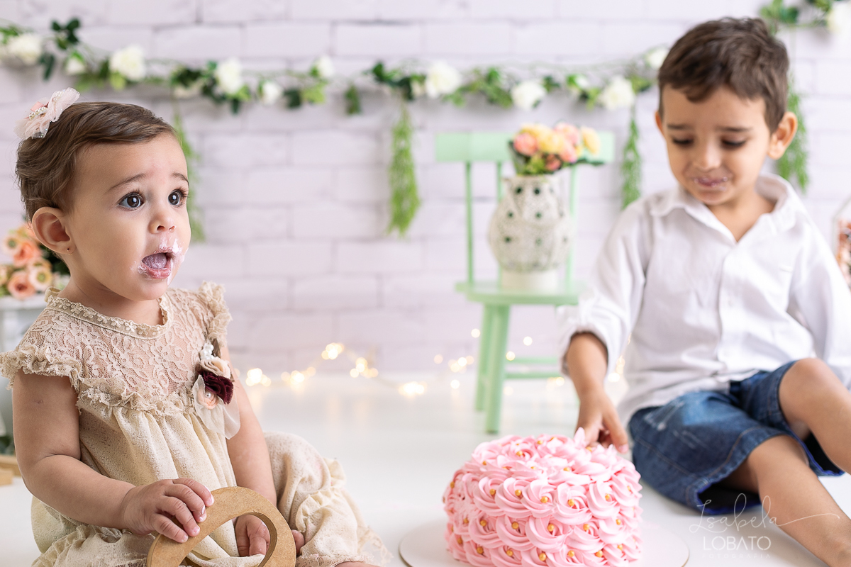 ensaio-fotografico-da-hora-do-bolo-esmagando-o-bolo-smash-the-cake-one-bebe-de-um-ano-acompanhamento-fotografico-de-bebes-fotografa-especializada-em-criancas-em-barbacena-isabela-lobato-fotografia-fundo-fotografico-de-smash-the-cake-cenario-fotografico