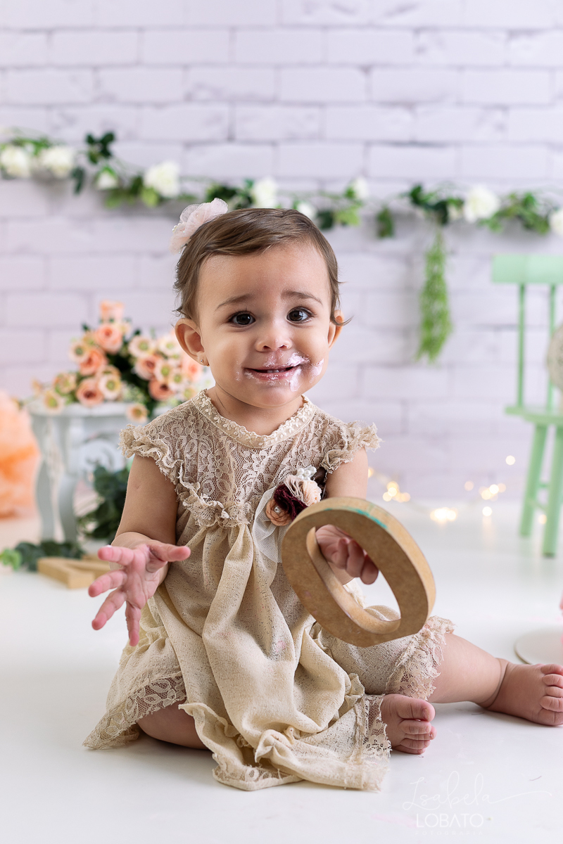 ensaio-fotografico-da-hora-do-bolo-esmagando-o-bolo-smash-the-cake-one-bebe-de-um-ano-acompanhamento-fotografico-de-bebes-fotografa-especializada-em-criancas-em-barbacena-isabela-lobato-fotografia-fundo-fotografico-de-smash-the-cake-cenario-fotografico