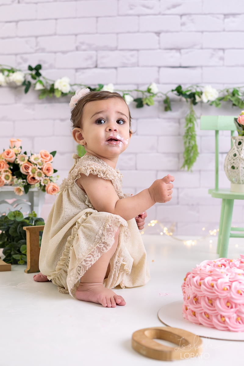 ensaio-fotografico-da-hora-do-bolo-esmagando-o-bolo-smash-the-cake-one-bebe-de-um-ano-acompanhamento-fotografico-de-bebes-fotografa-especializada-em-criancas-em-barbacena-isabela-lobato-fotografia-fundo-fotografico-de-smash-the-cake-cenario-fotografico