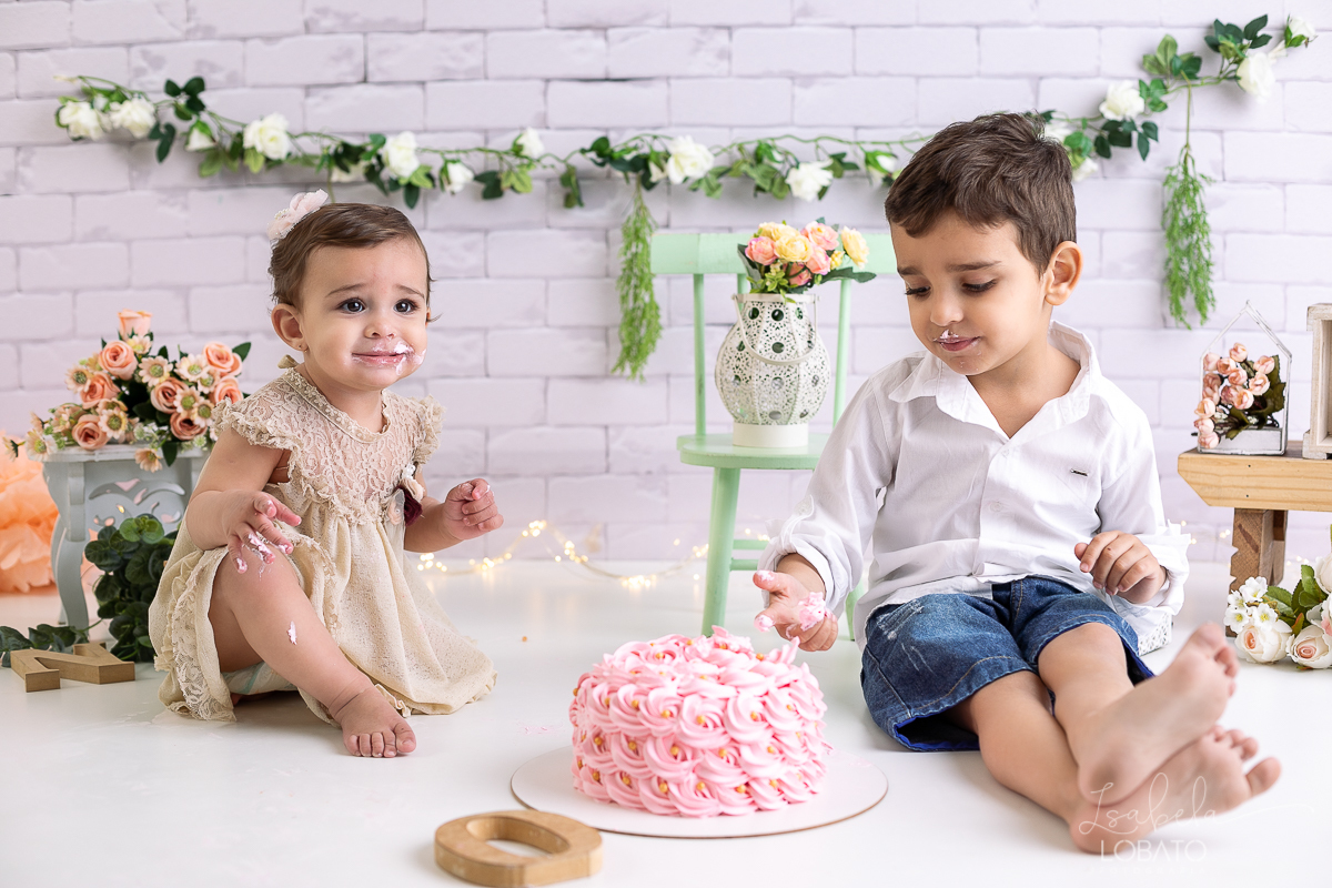 ensaio-fotografico-da-hora-do-bolo-esmagando-o-bolo-smash-the-cake-one-bebe-de-um-ano-acompanhamento-fotografico-de-bebes-fotografa-especializada-em-criancas-em-barbacena-isabela-lobato-fotografia-fundo-fotografico-de-smash-the-cake-cenario-fotografico
