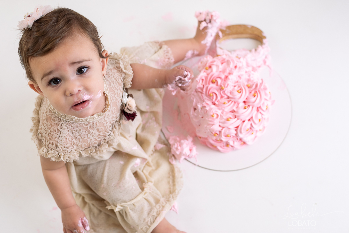ensaio-fotografico-da-hora-do-bolo-esmagando-o-bolo-smash-the-cake-one-bebe-de-um-ano-acompanhamento-fotografico-de-bebes-fotografa-especializada-em-criancas-em-barbacena-isabela-lobato-fotografia-fundo-fotografico-de-smash-the-cake-cenario-fotografico
