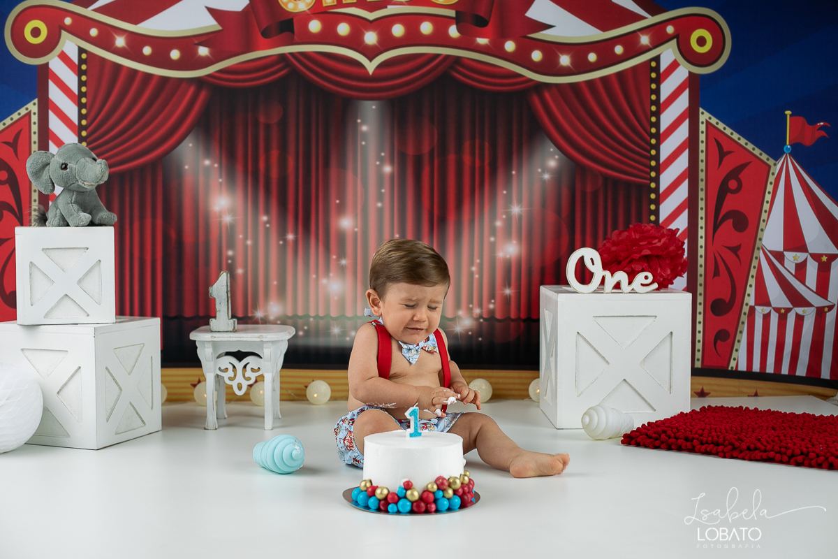 smash-the-cake-baby-one-ensaio-fotografico-de-um-ano-a-hora-do-bolo-esmagando-o-bolo-fotografia-acompanhamento-mensal-de-bebes-um-ano-decoracao-de-cenario-fotografico-circo-fundo-fotografico-do-circo-roupa-de-palhaço-bb-fases-do-bebe-fotografa-infantil-bq