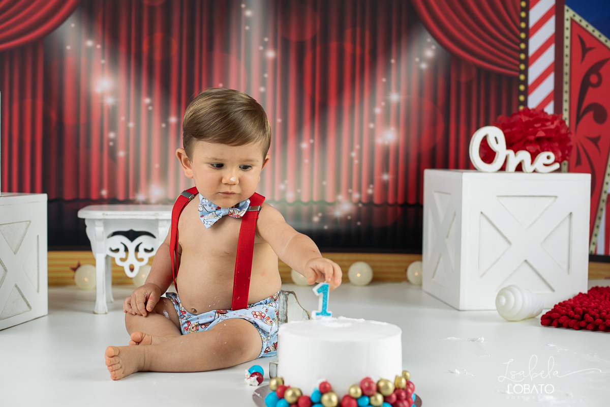 smash-the-cake-baby-one-ensaio-fotografico-de-um-ano-a-hora-do-bolo-esmagando-o-bolo-fotografia-acompanhamento-mensal-de-bebes-um-ano-decoracao-de-cenario-fotografico-circo-fundo-fotografico-do-circo-roupa-de-palhaço-bb-fases-do-bebe-fotografa-infantil-bq