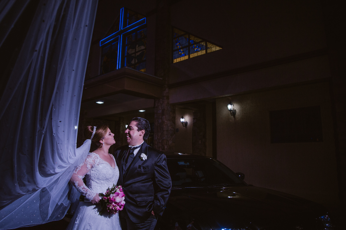 foto ao lado de fora da igreja com os noivos alegres pela linda cerimonia