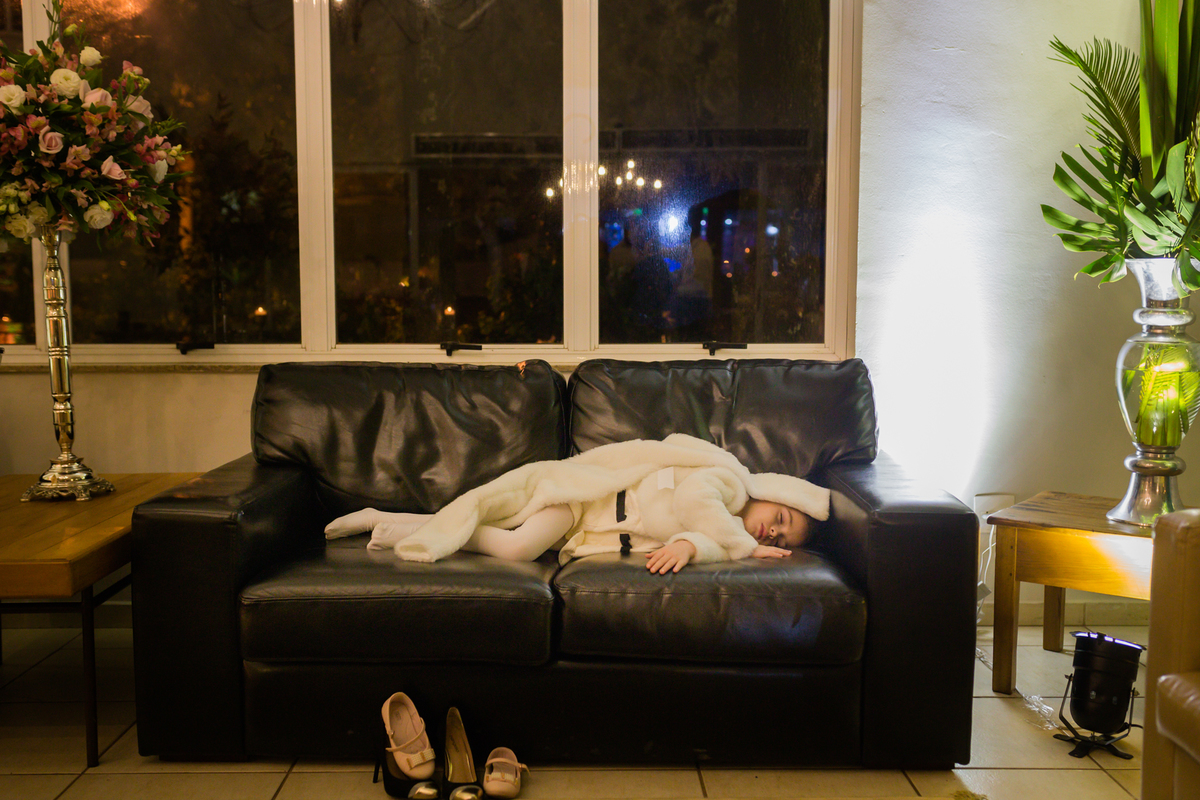 uma criança deitada dormindo no sofá em plena recepção