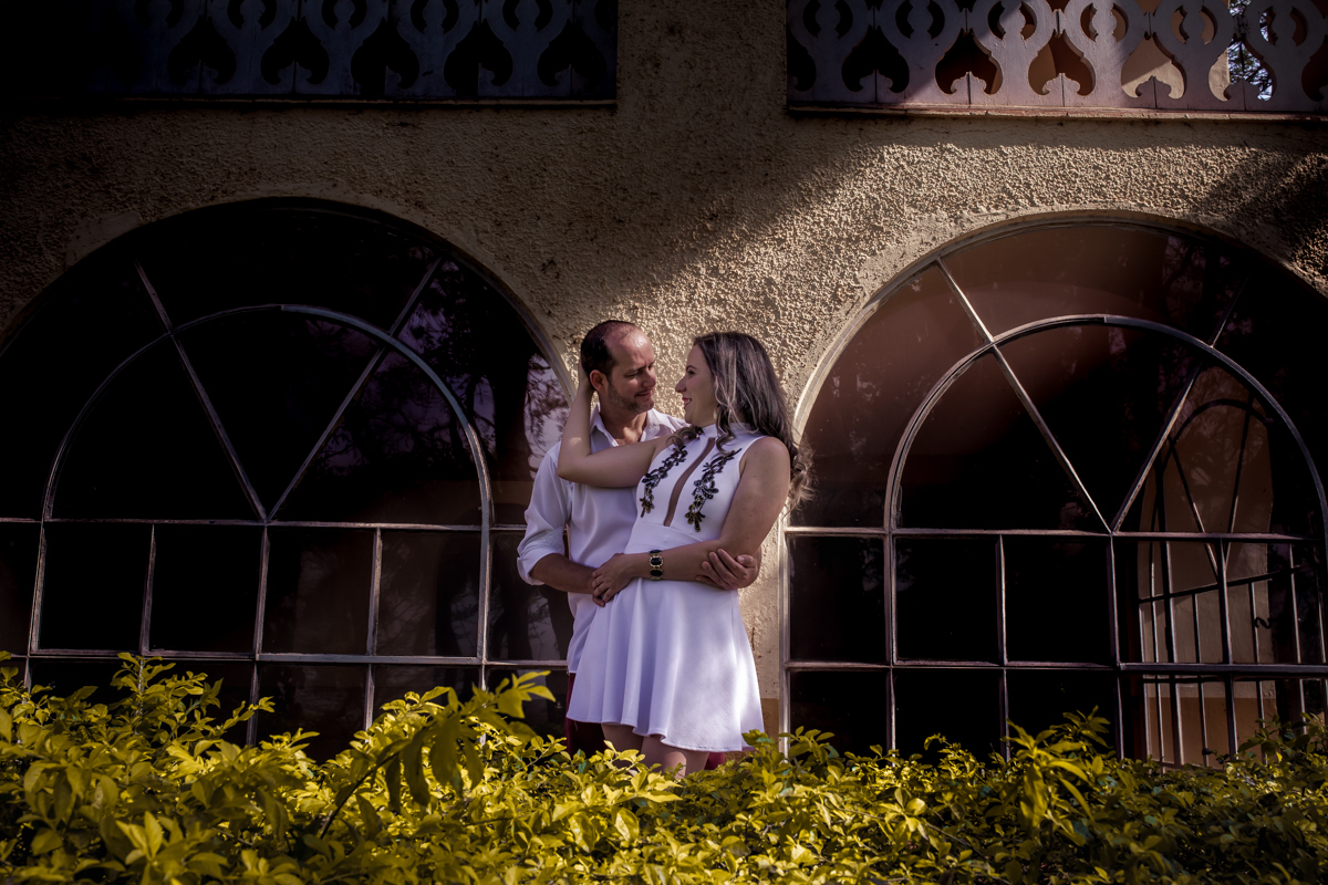 Casal trocando carinho próximos da janela da fazenda