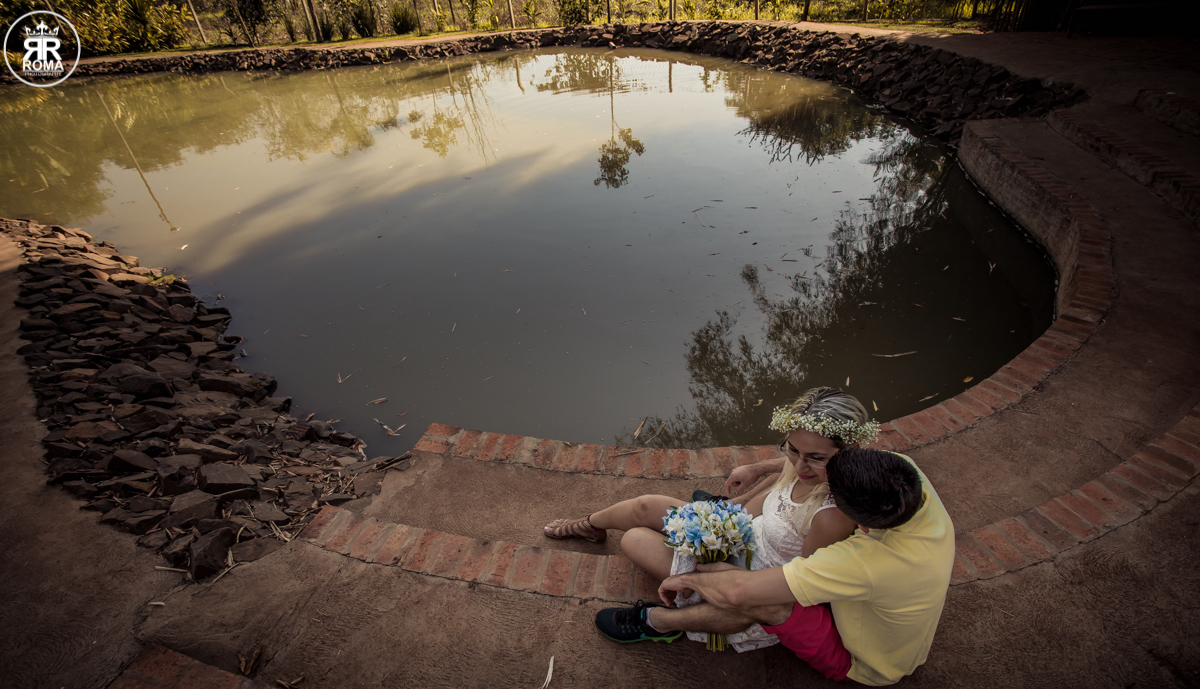 casal sentado a beira do lago em formato de coração