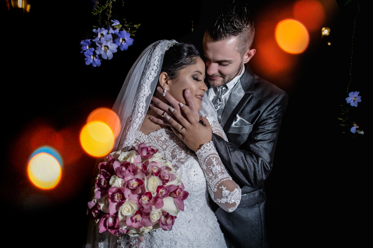 noivos abraçadinhos e apaixonados entre as luzes do local