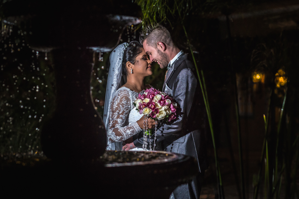 noivos abraçando-se próximos a fonte de águas limpas