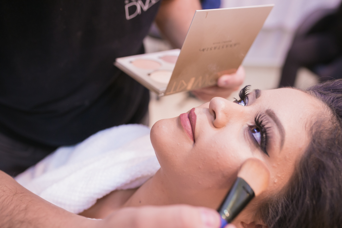 maquiadora nos últimos retoques com o pincel perto dos olhos