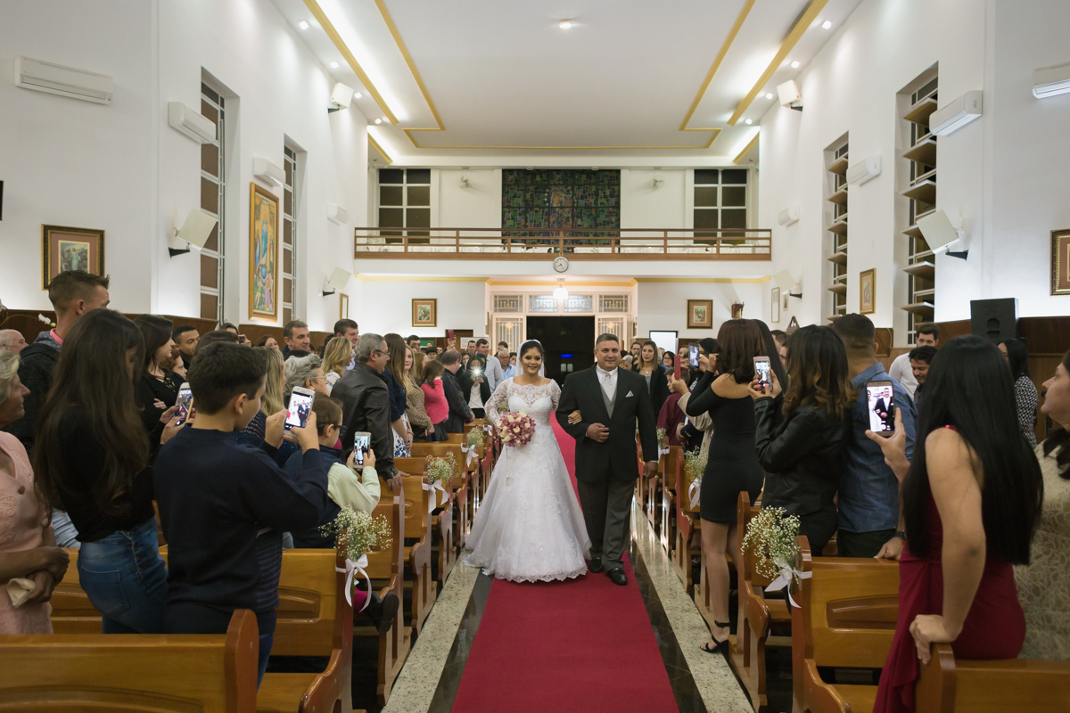 noiva no corredor central da igreja São Benedito de braços dados com o seu pai
