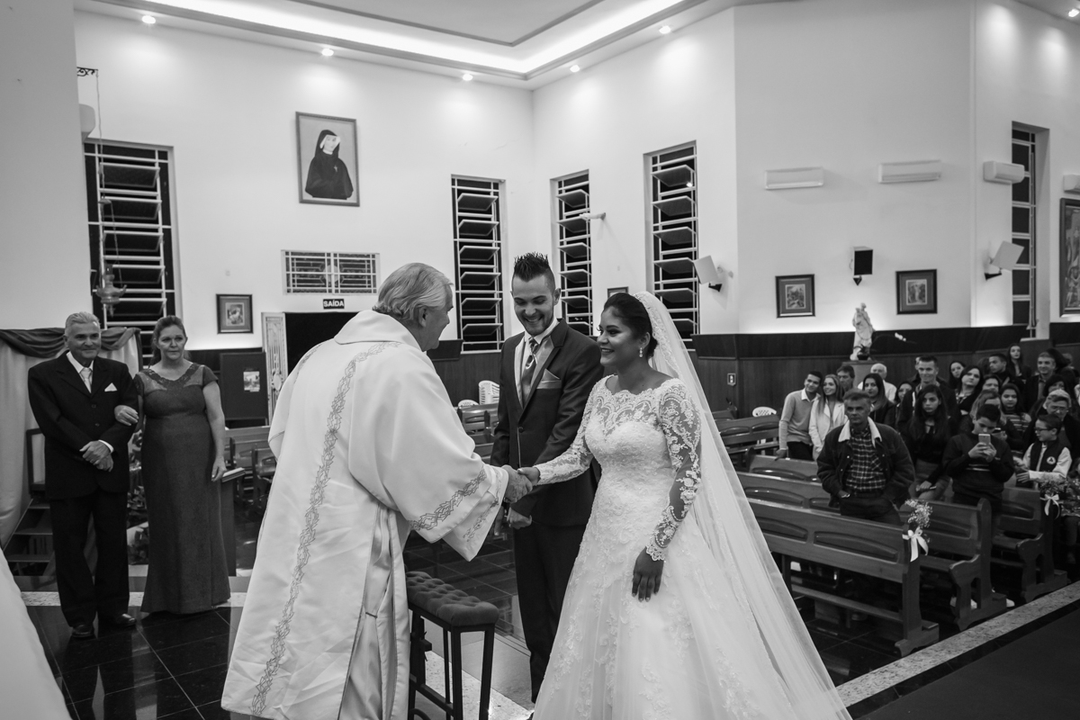 Padre cumprimentando e dando as boas novas para a  noiva no altar