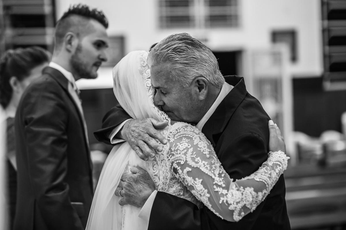 pai da noiva abraçando-a com  muita emoção