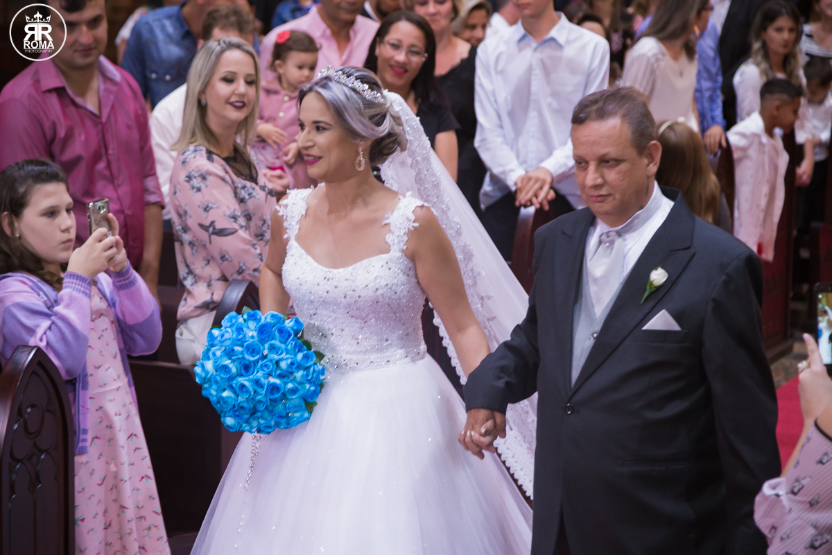 a noiva brinca com convidados enquanto desfila pelo corredor da igreja