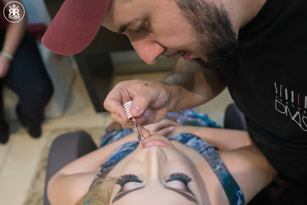 maquiador dando os últimos retoques  com o batom na boca da noiva