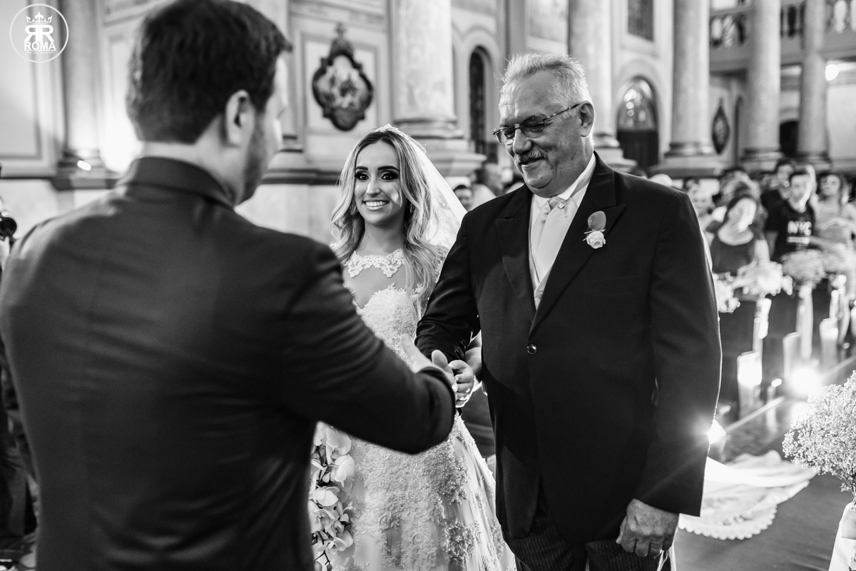 foto em preto e branco do pai da noiva dando as mãos ao noivo