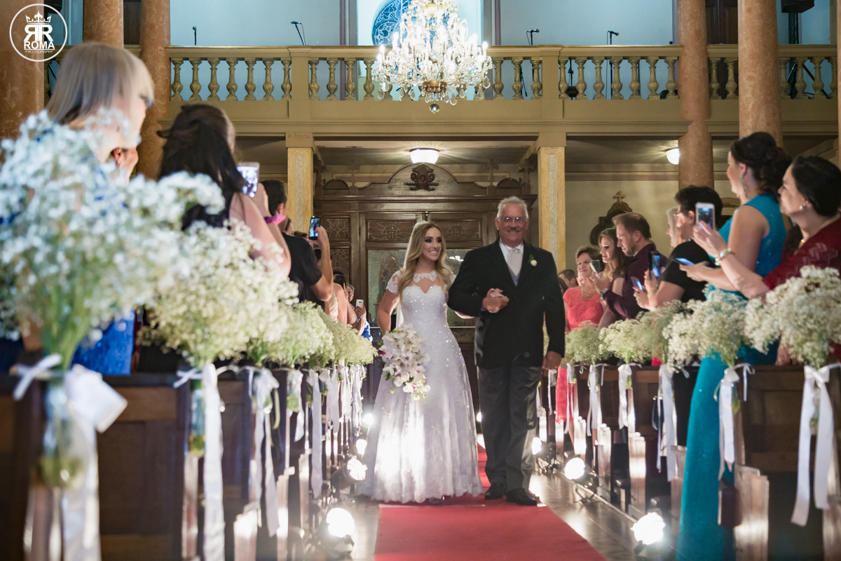 vista de frente da entrada da noiva de braços dados com o seu pai