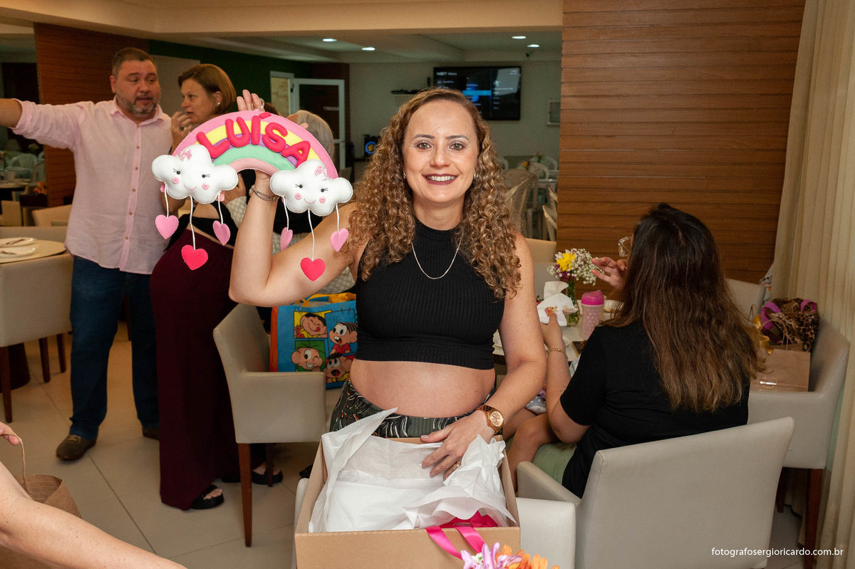 foto da gestante recebendo presente durante o chá de fralda com tema dunbo baby na cor rosa