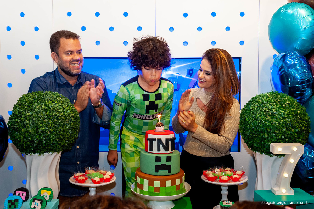 foto do aniversariante com os pais cantando parabéns com decoração de aniversário infantil tema minecraft na animasom via parque na barra da tijuca rio de janeiro