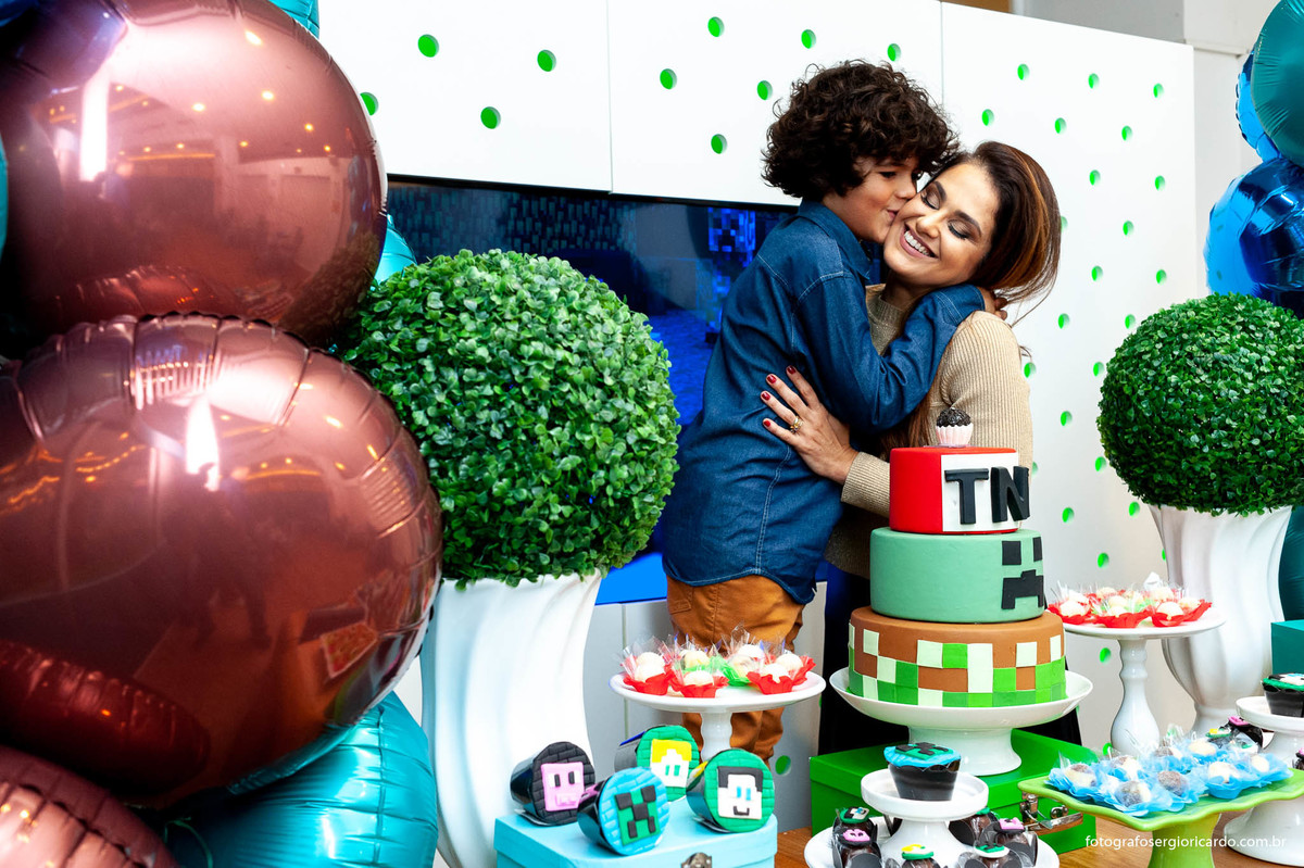 foto do aniversariante com a mãe com decoração de tema minecraft na animasom via parque na barra da tijuca rio de janeiro