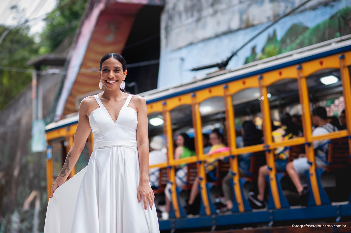 Imagem da noiva com vestido de casamento na porta do hotel mgallery em santa teresa com o bandinho ao fundo no rio de janeiro