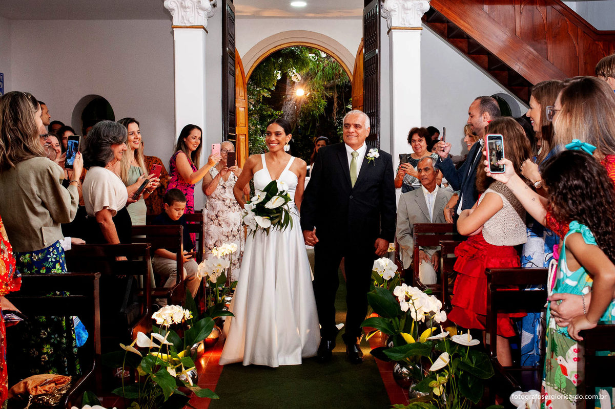 imagem da noiva entrando com o pai na capela santa ignez no bairro da gávea no rio de janeiro