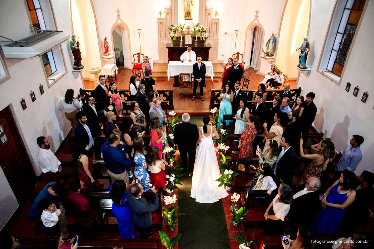 imagem da noiva entrando com o pai na capela santa ignez no bairro da gávea no rio de janeiro