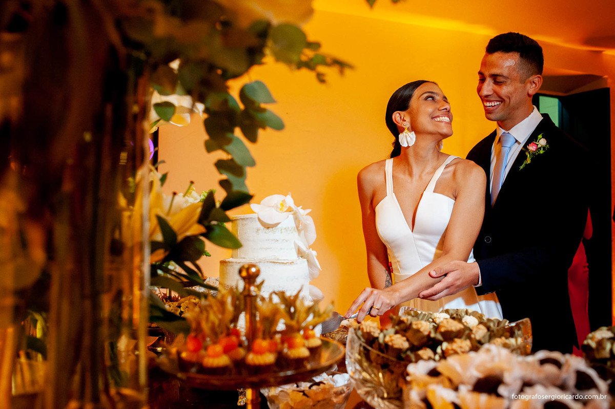 imagem dos noivos cortando o bolo na casa santa ignez no bairro da gávea no rio de janeiro