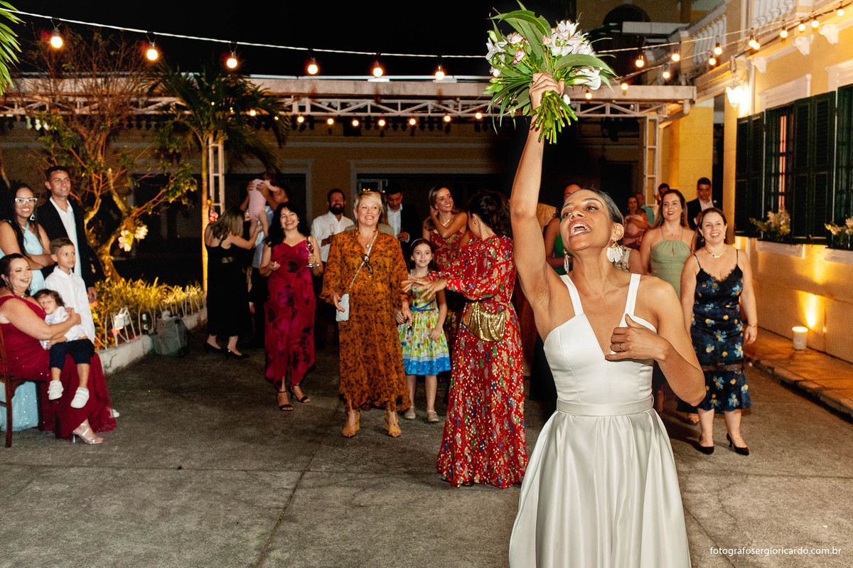 imagem da noiva jogando o bouquet na casa santa ignez no bairro da gávea no rio de janeiro