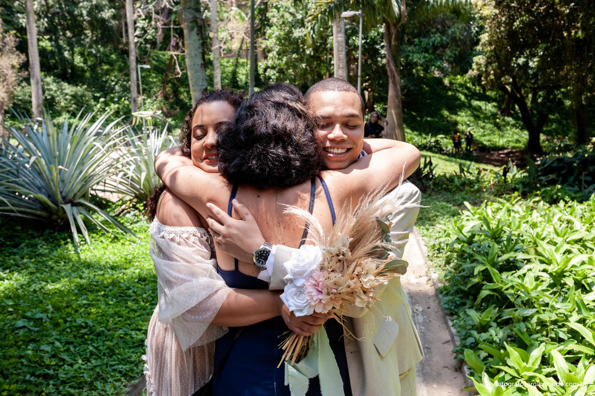 fotografia dos noivos abraçando convidada na cerimônia de casamento realizado no parque guinle em laranjeiras no rio de janeiro