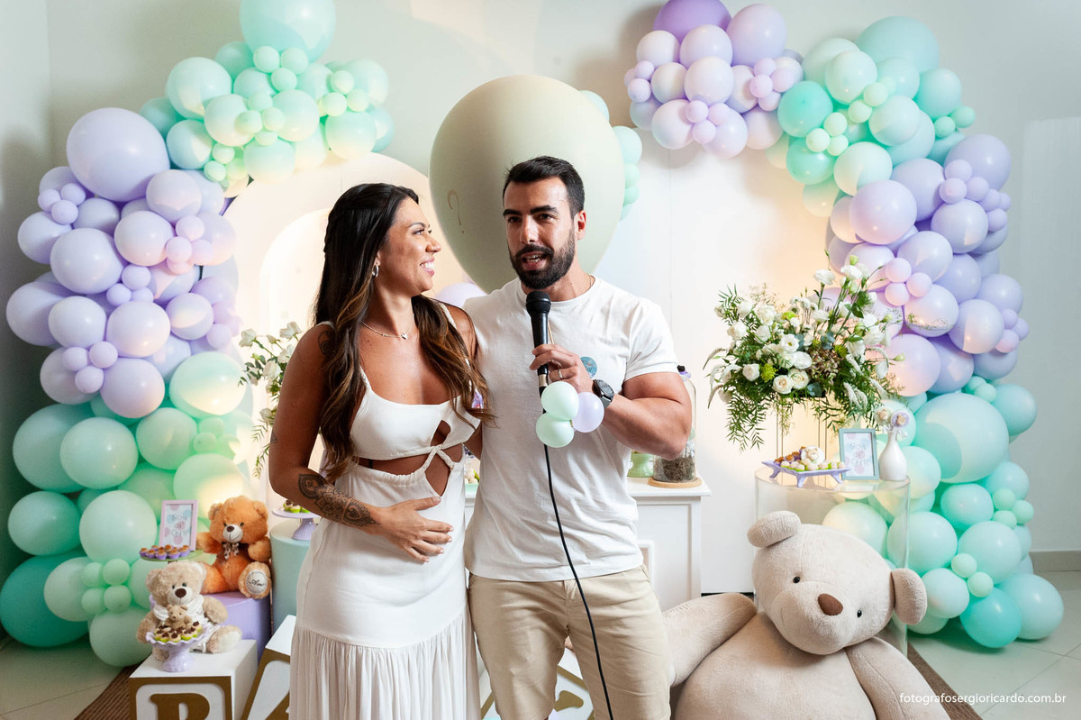 foto do casal anunciando o nome da criança durante o chá revelação com decoração verde e lilás no rio de janeiro