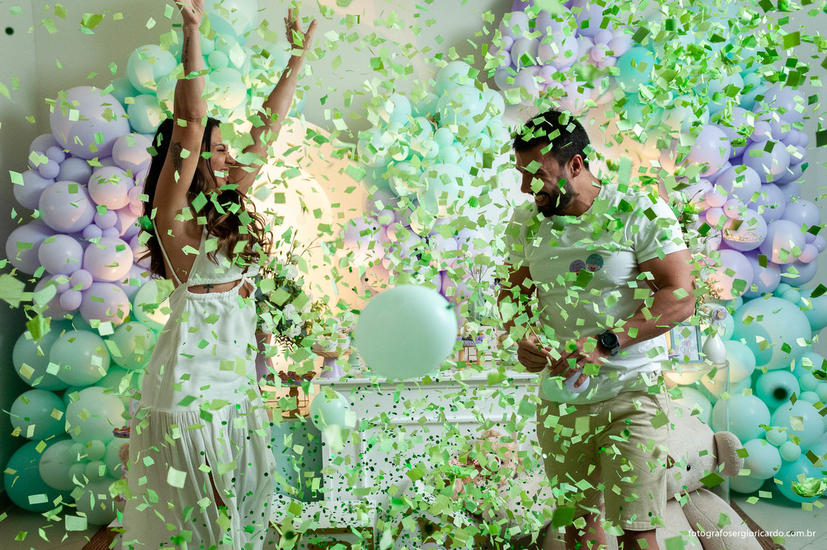 foto do casal anunciando o nome da criança durante o chá revelação com decoração verde e lilás no rio de janeiro