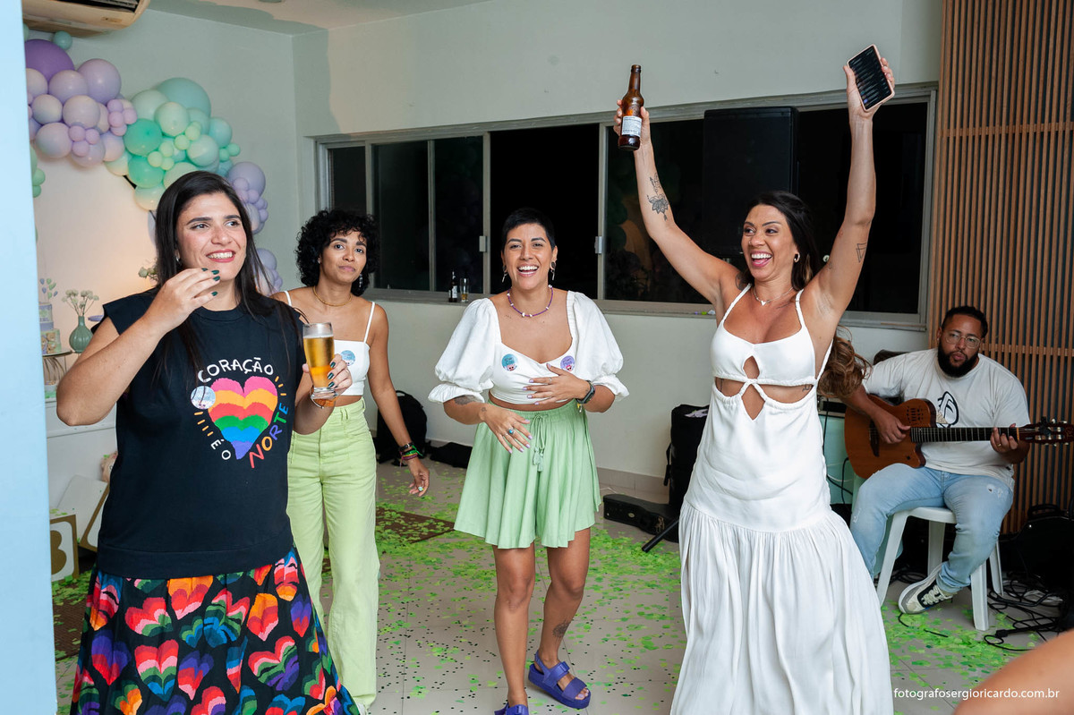 foto da gestante com as amigas comemorando após o anúncio do nome da criança durante o chá revelação com decoração verde e lilás no rio de janeiro