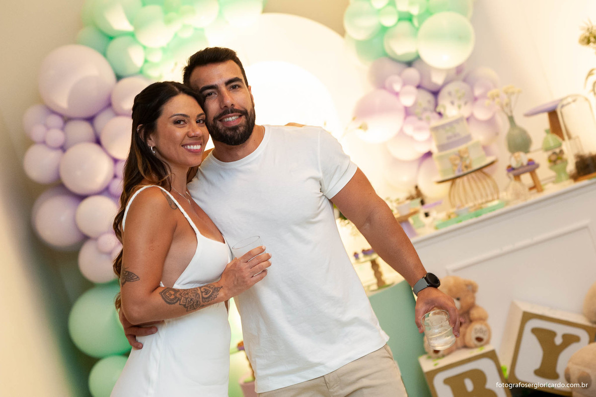 foto do casal após o anúncio do nome da criança durante o chá revelação com decoração verde e lilás no rio de janeiro