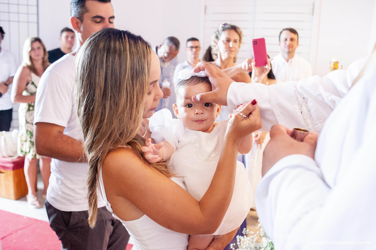 Fotografia da madrinha com criança na cerimônia de batismo na Capela de Nossa Senhora Aparecida no Cristo Redentor localizado no Morro do Corcovado no Rio de Janeiro