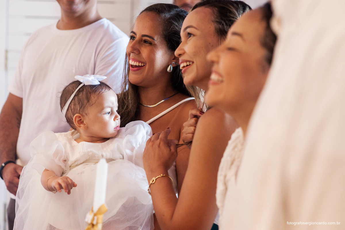 Fotografia da madrinha com criança na cerimônia de batismo na Capela de Nossa Senhora Aparecida no Cristo Redentor localizado no Morro do Corcovado no Rio de Janeiro