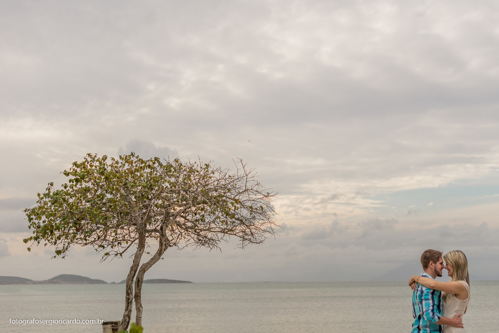 Retrato do casal namorando perto de uma árvore na praia de Manguinhos em Búzios no Rio de janeiro