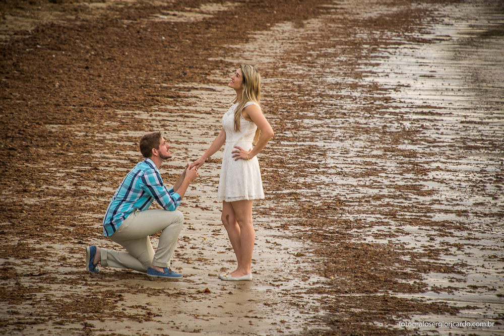Foto do noivo pedindo a mão da noiva em casamento ao entardecer na praia de Manguinhos em Búzios no Rio de Janeiro