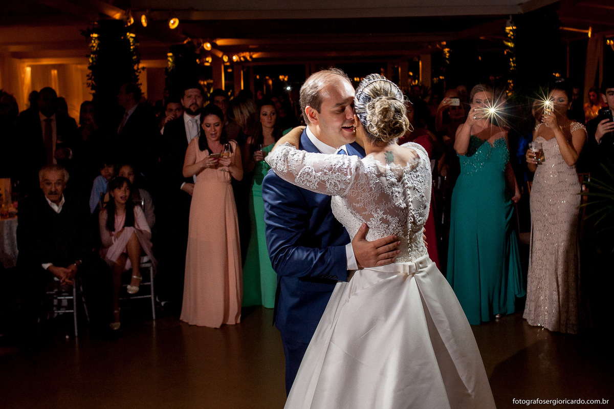 primeira dança dos noivos com convidados fazendo fotografia