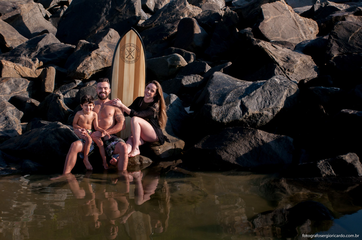 Retrato de uma família sentada nas pedras da praia do Recreio.